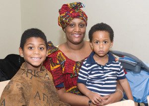 A woman and two boys sitting next to each other.