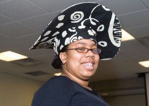 A woman wearing an african hat and glasses.