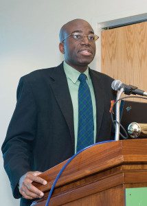 A man in a suit and tie standing at a podium.
