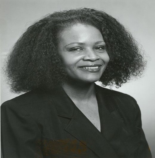 A black and white photo of a woman with big hair.