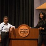 Two people standing in front of a podium